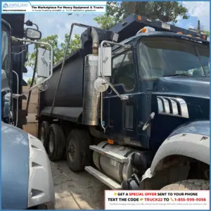 Blue heavy-duty dump truck with chrome exhaust and side steps, parked among other trucks with a SimpleLend ad banner above.